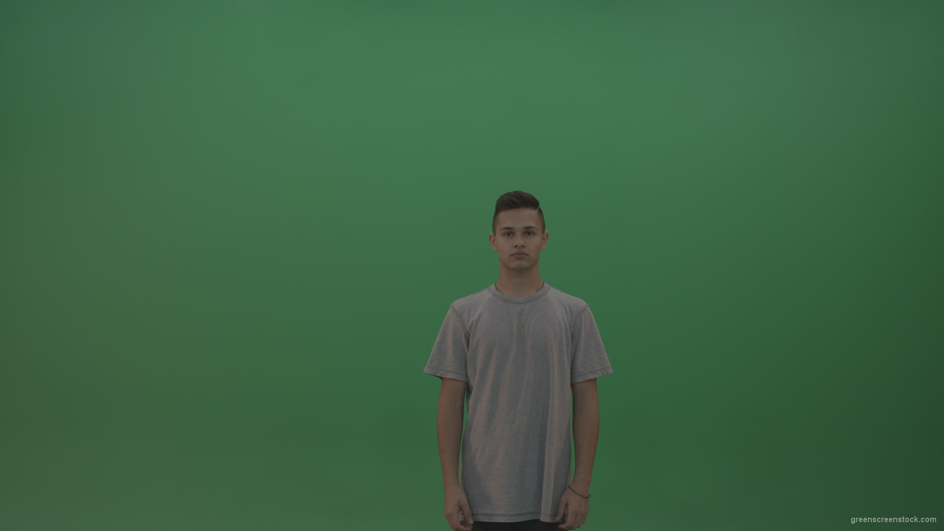 Boy-in-grey-wear-expresses-approval-by-giving-thumbs-up-over-green-screen-background_001 Green Screen Stock