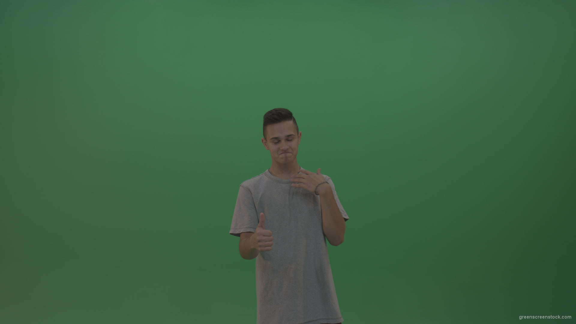 Boy-in-grey-wear-expresses-approval-by-giving-thumbs-up-over-green-screen-background_004 Green Screen Stock