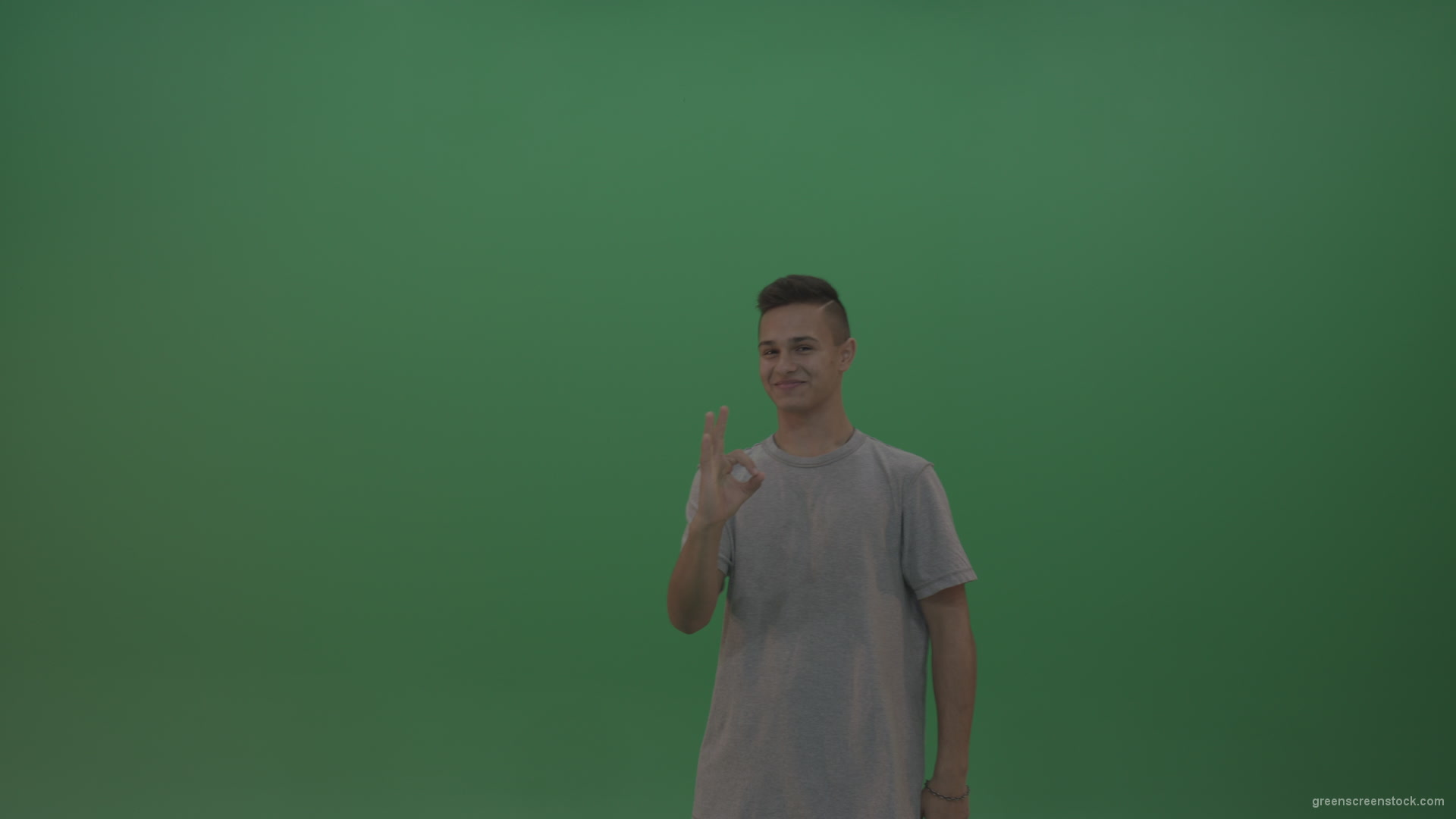 Boy-in-grey-wear-expresses-approval-by-giving-thumbs-up-over-green-screen-background_006 Green Screen Stock