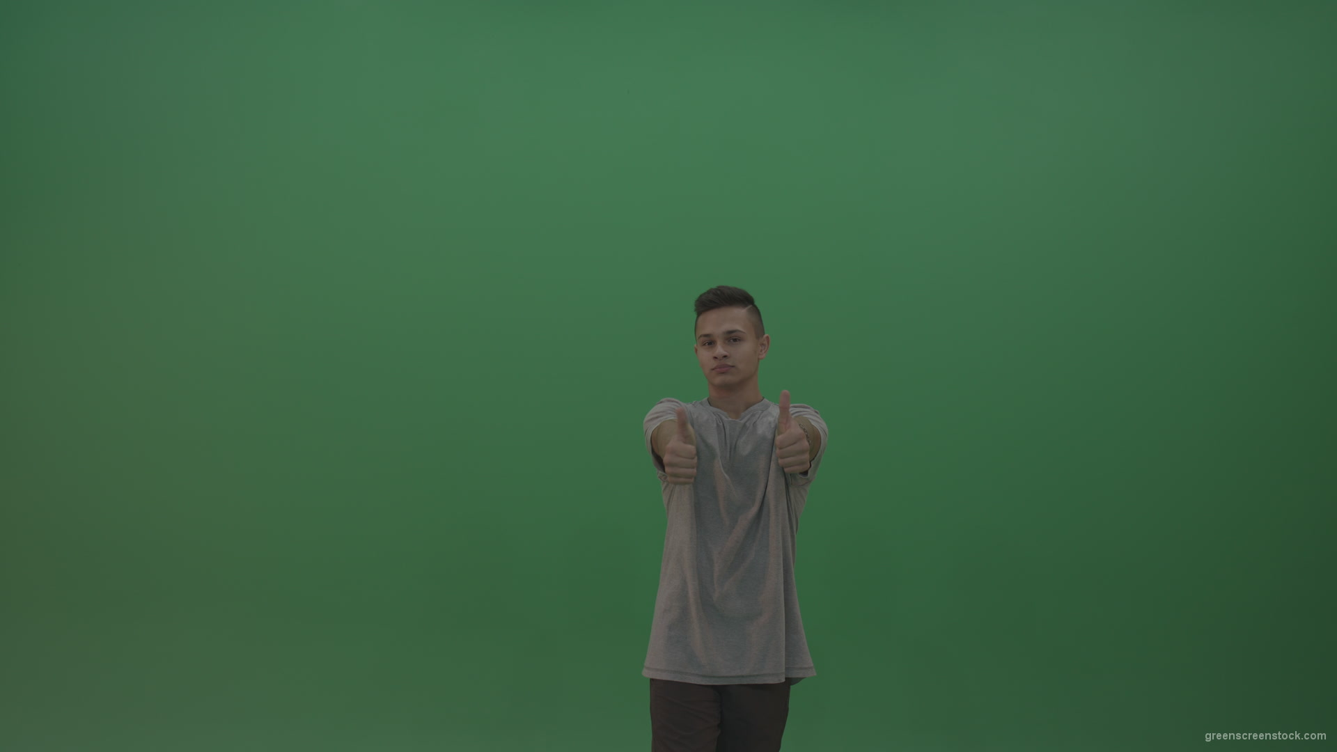 Boy-in-grey-wear-expresses-approval-by-giving-thumbs-up-over-green-screen-background_008 Green Screen Stock