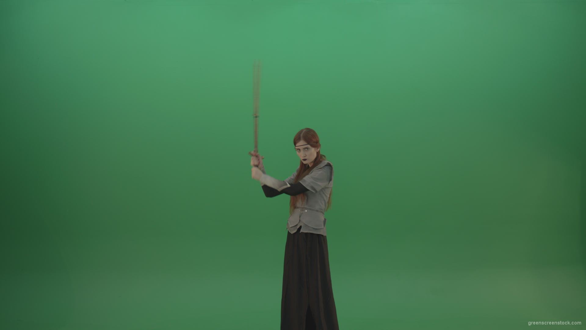 Fighting-girl-in-silver-armor-swinging-with-the-sword-aiming-at-one-goal-on-chromakey_002 Green Screen Stock