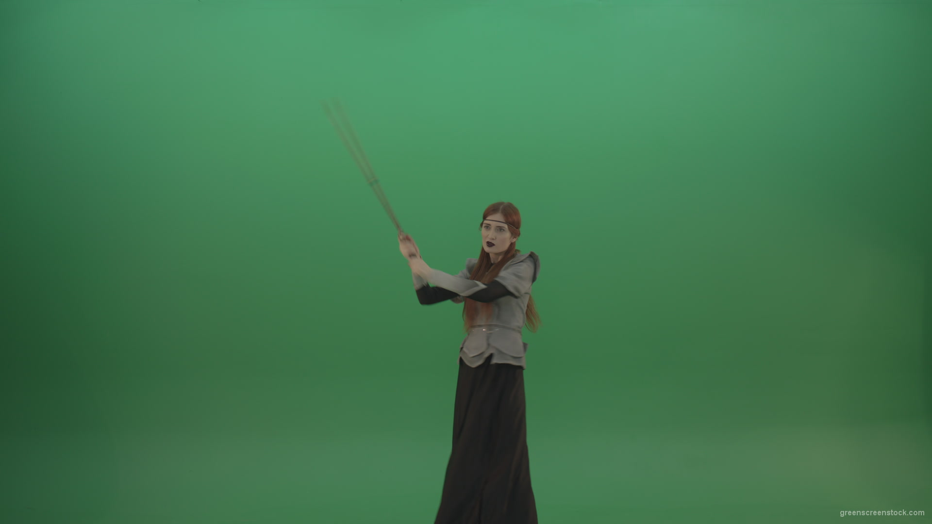 Fighting-girl-in-silver-armor-swinging-with-the-sword-aiming-at-one-goal-on-chromakey_006 Green Screen Stock