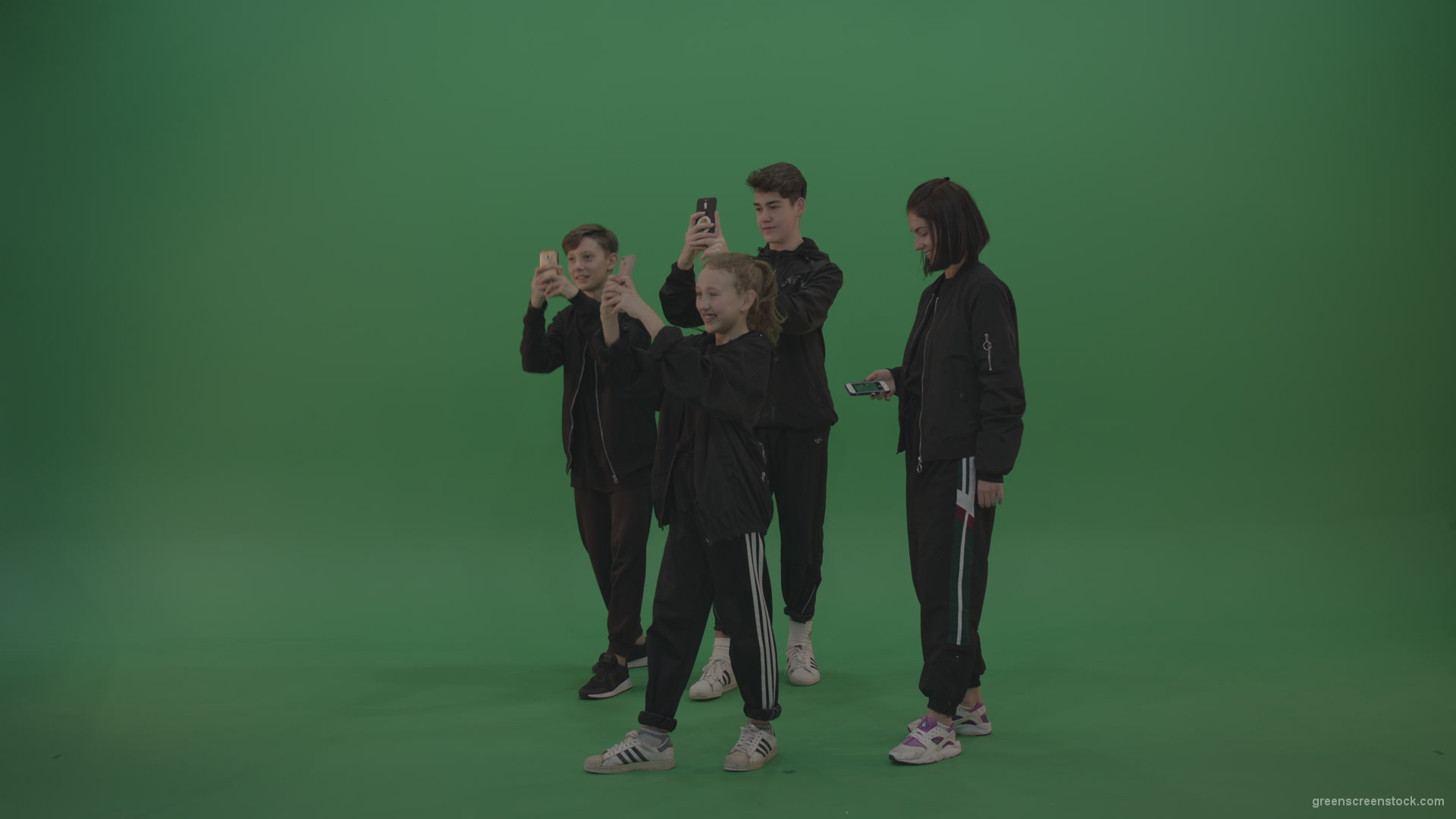 Four-kids-in-black-wears-take-pictures-over-chromakey-background_001 Green Screen Stock