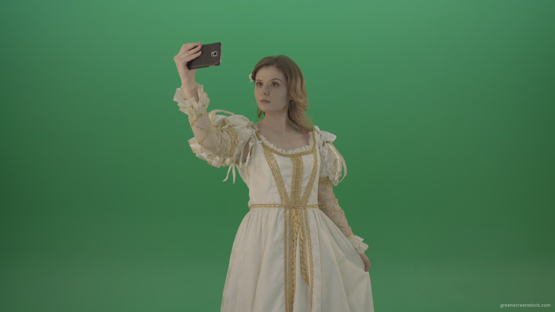 Princess-girl-dressed-in-a-light-suit-makes-a-sephi-on-a-modern-phone-isolated-on-chromakey-background_004 Green Screen Stock