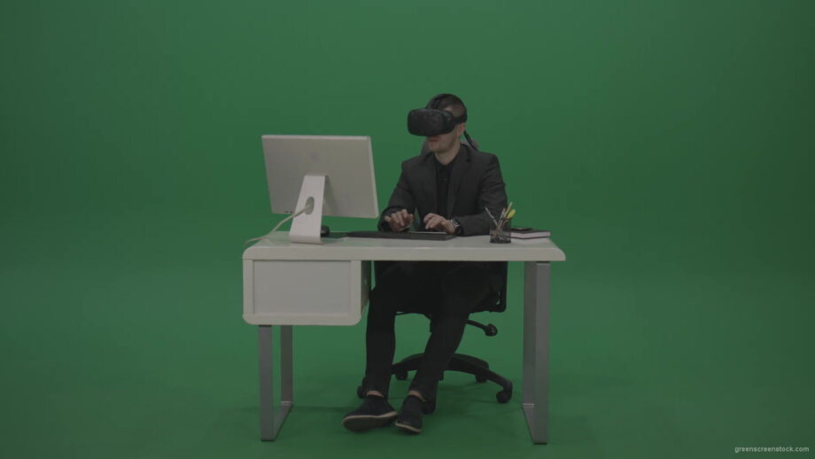 vj video background Young_Handsome_Businessman_Wearing_Dark_Suite_Sitting_At_The_Office_Table_Typing_Message_Using_VR_Glasse_Green_Screen_Wall-1920_003